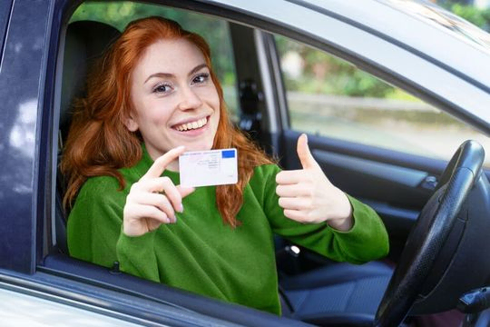 mujer en coche mostrando el carnet de conducir