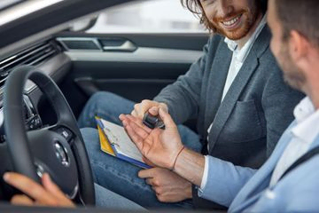 dos hombres firmando contrato en coche